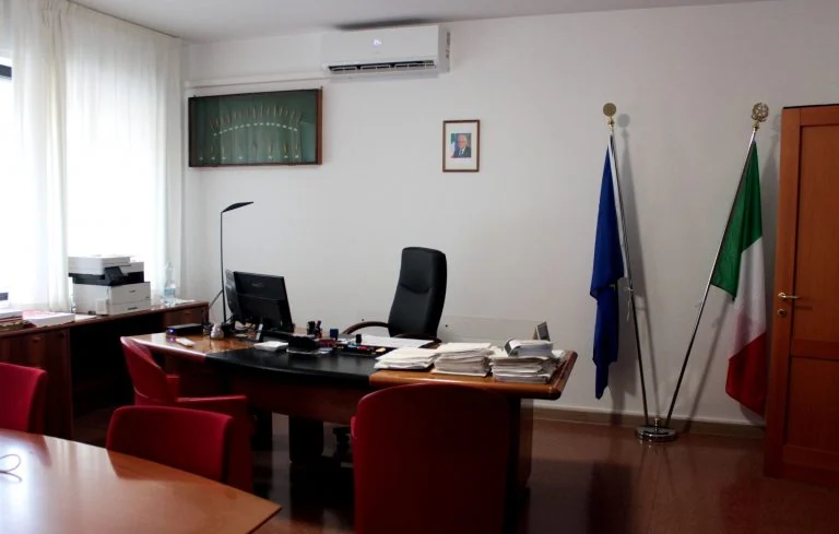 Ufficio con scrivania e bandiere italiana ed europea