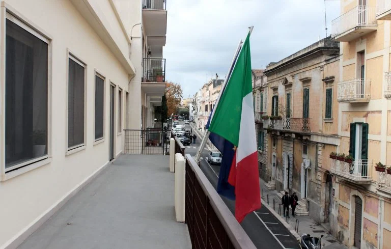 Balcone dell’Archivio con bandiera italiana e veduta della strada