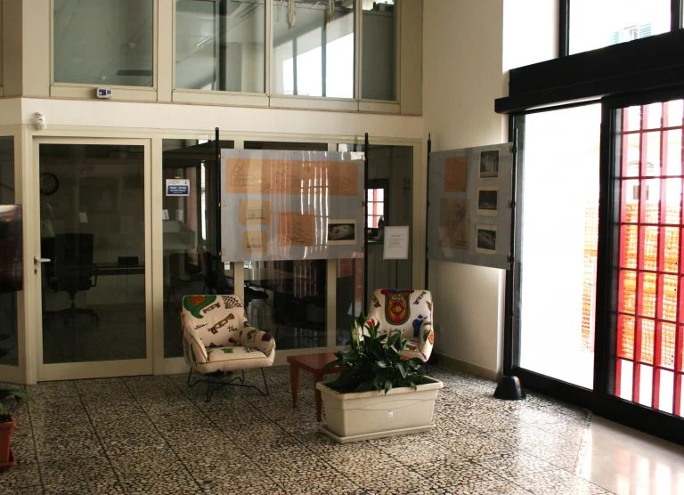 Vetrine e materiali esposti vicino alle finestre dell’atrio