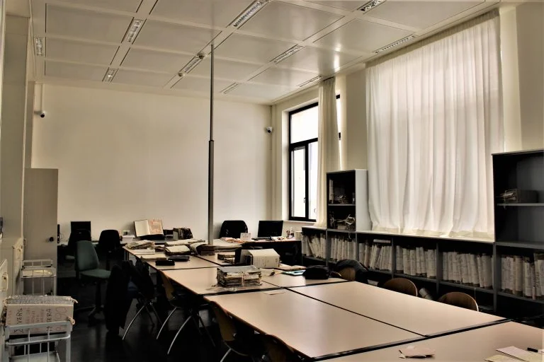 Sala di consultazione con scaffali lungo le finestre