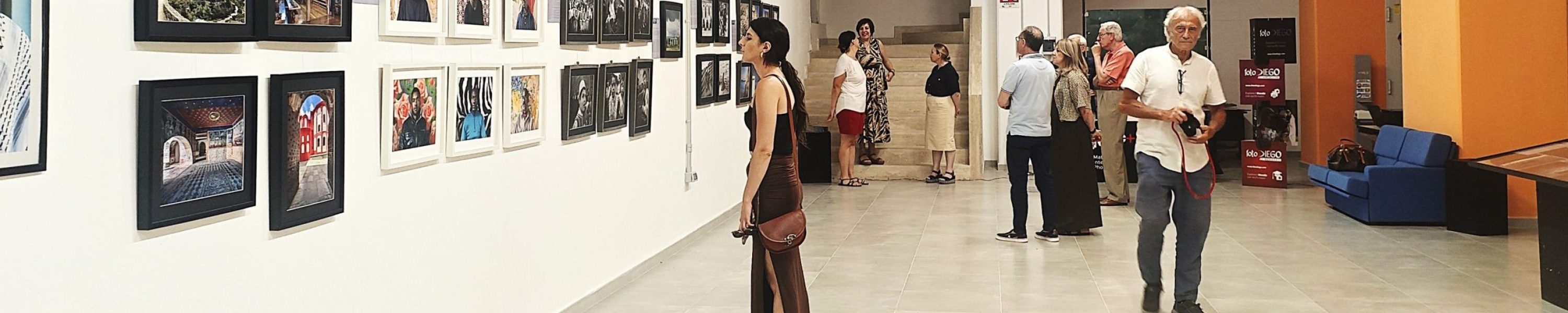 Visitatori osservano una mostra fotografica negli spazi dell’Archivio